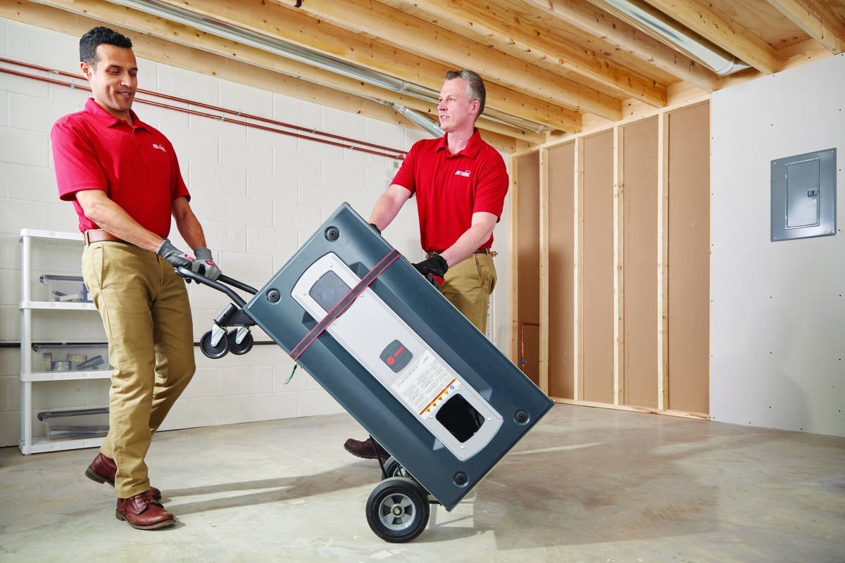 Two technicians delivering a furnace for installation